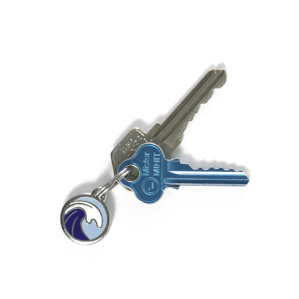 A set of house keys on a ring with a round enamel blue wave ID tag